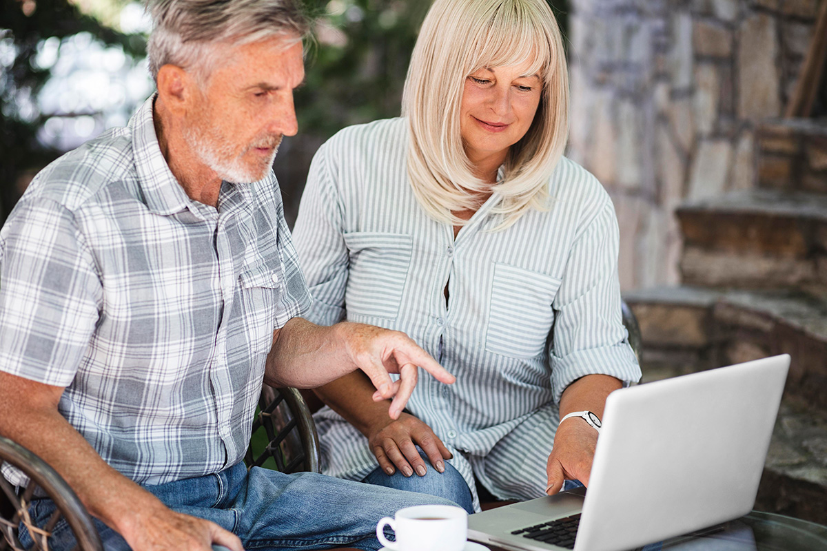 medium shot couple looking laptop