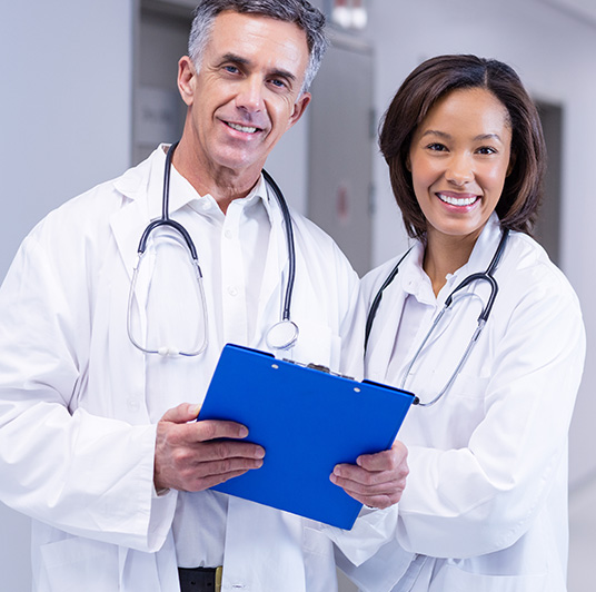 portrait smiling doctors standing corridor
